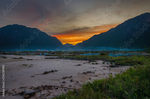 Photography A scenic view showing a lake in the foreground and mountains in the background at sunset