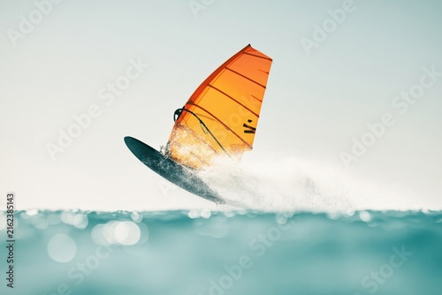 Windsurfer glides over the water in a vibrant display of sport and skill on a sunny day
