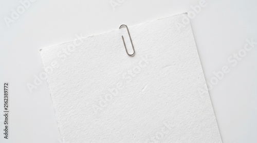 paper card with metal paper clip on white background for note, memo, background, message, template, or mockup.
