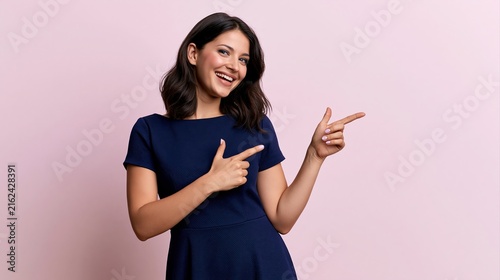 Smiling woman in blue dress pointing with both hands