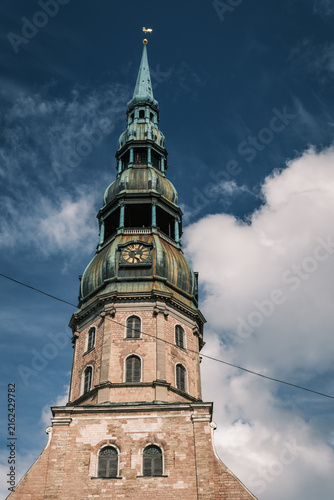 Foto Vertical view of the towering wooden steeple and clock tower of St Peter Church