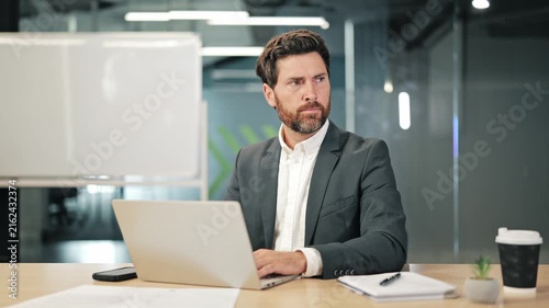 Professional concentrates on laptop. Suddenly startled by loud sounds. Covers ears, reacting with distress, shouting in frustration. Shows feeling of overwhelm and discomfort.