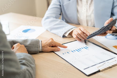 Business meeting, asian group brainstorm analysis on graph data of cost plan. financial consult planning investor asses and present to client, client and advisor review investment strategy in office.