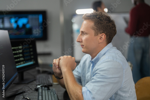 Photography Caucasian male programmer coding on computer monitors in modern IT office, Softw