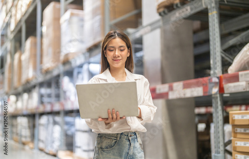 Female engineer is handling shipping and checking stock inventory in the warehouse with a laptop, industry, import-export, inventory management, logistics, global transportation at warehouse, business