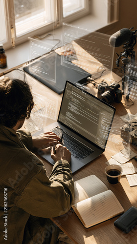 Developer Working on Laptop with Futuristic Digital Code Overlay and Handwritten Notes