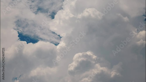 White puffy clouds drifting across a bright blue sky during a sunny afternoon capturing nature in motion