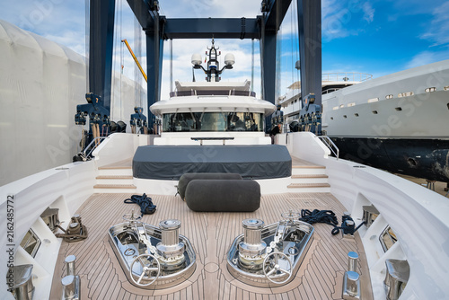 фотографія Superyacht being hauled out for shipyard period with travel lift crane with blue