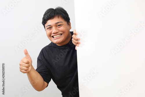 Foto A studio photo of a heavy-set man holding a large, blank white board—providing space for promotional text or images—while giving a thumbs-up against a white background