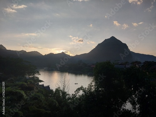Photography Scenic lake view at sunset with mountains and silhouettes of trees in the foreground