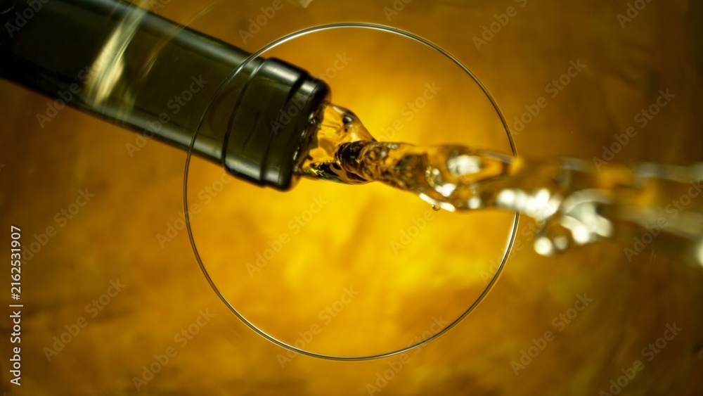 Naklejka premium White Wine Pouring Into Glass From Below