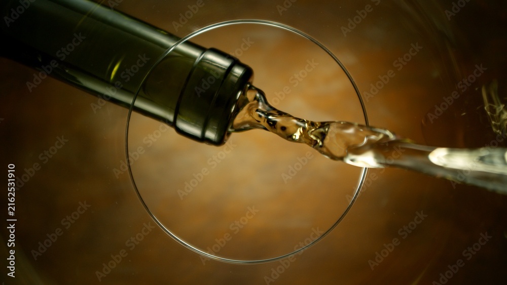 Naklejka premium White Wine Pouring Into Glass From Below