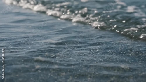 Calm ocean water surface reflecting soft daylight, gentle ripples across the expanse, perfect for nature themed videos, serene background footage, tranquil mood setting