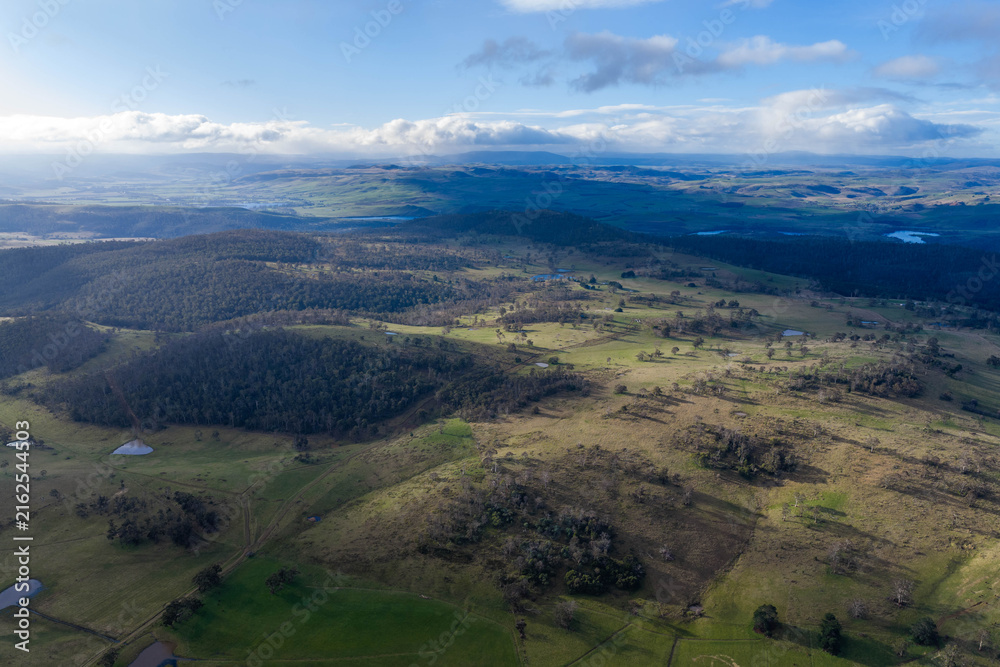 Fototapeta premium Aerial Drone View of Rolling Rural Hills, Pasture and Forested Australian Landscape