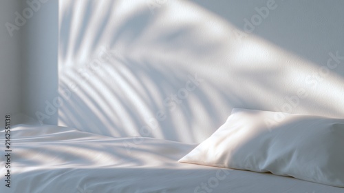 Close-up of a bed with white sheets and pillows. the bed is in a room with a white wall on the right side and a window on the left side.