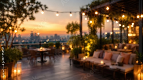 soft bokeh blur of luxury rooftop bar at sunset, warm string lights, cozy lounge seating, city skyline background, elegant outdoor dining terrace.