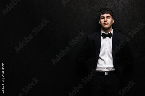 Gen Z young man in black tuxedo with wide copy space for advertising