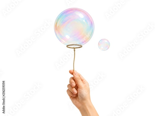 Hand holding a thin metal wand with a large iridescent soap bubble and a smaller bubble floating nearby isolated on white background