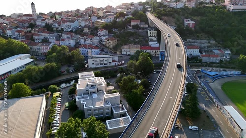 Bridge curves uphill.
Highway reaches hillside.
City surrounds viaduct.
Water meets horizon.
