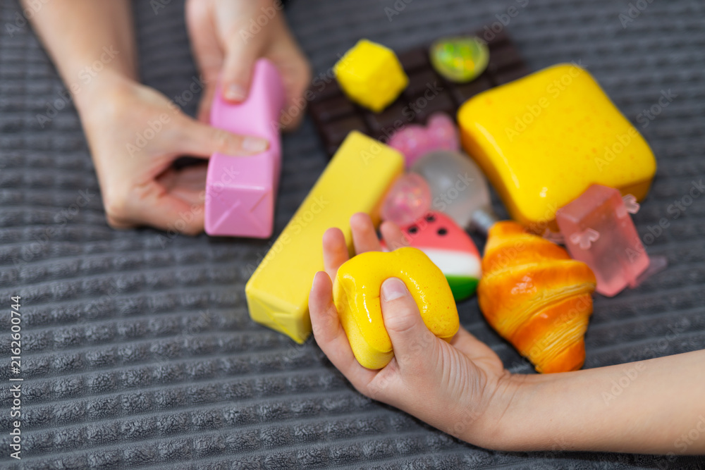 Naklejka premium Two children playing with vibrant squishy toys and foam food pieces for kids playroom background and early learning activity design