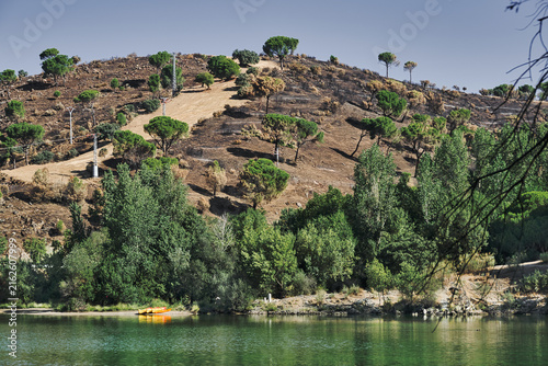 Burned hillside above San Juan Reservoir after summer wildfires in Pelayos de la Presa, Sierra Oeste de Madrid, Spain.