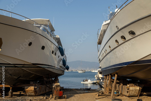 Canvastavla Two luxury yachts undergoing maintenance on dry dock stands at a shipyard