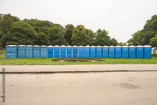 Konstfotografi Row of blue portable toilets at outdoor event.