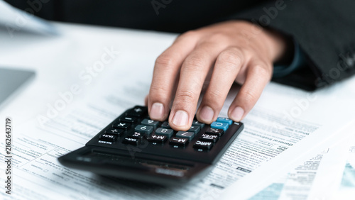 The image of a hand pressing buttons on a calculator on a document reflects the meticulousness in handling taxes and finances. Every number is accurate, helping to plan for a secure business future.