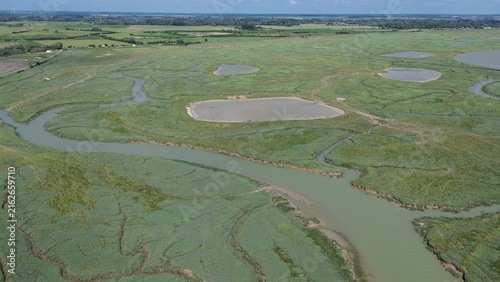 Photography Top down aerial view of winding water channels and green salt marsh islets in So