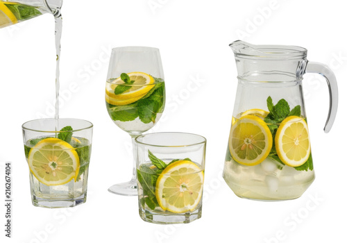 Refreshing lemonade with fresh lemon slices and mint leaves in a glass pitcher and glasses isolated on transparent background