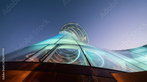 Futuristic Glass Funnel Architectural Structure with Blue-Green Spiral Design