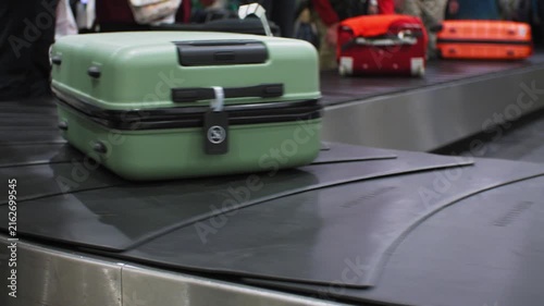 Bright green suitcase being moved around on baggage conveyor at an airport, 4k