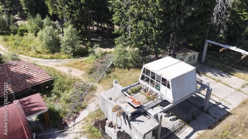 Aerial view of an abandoned ski lift station and old building in the mountain forest