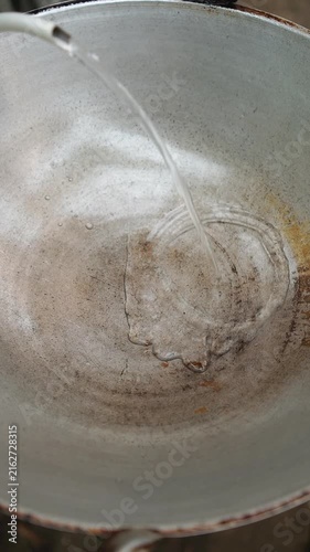 Cooking Thai crispy black pomfret (Pla Jalamed Dam Thod). Deep-frying whole fish until golden, simmer-stirring Chinese celery in sauce, and topping over fish.