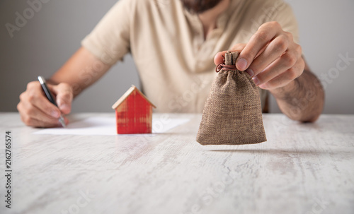 Man with a money bag and house model.