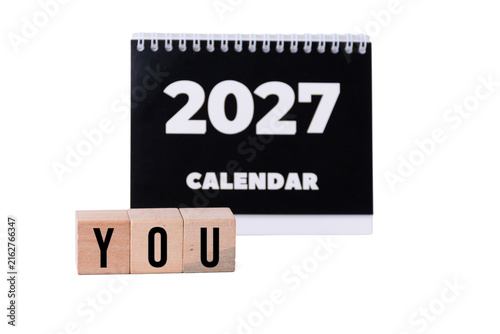YOU word on wooden blocks with small black 2027 desk calendar isolated on white