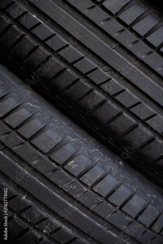 View of black rubber car tires with detailed tread patterns stacked together in Riga, Latvia.