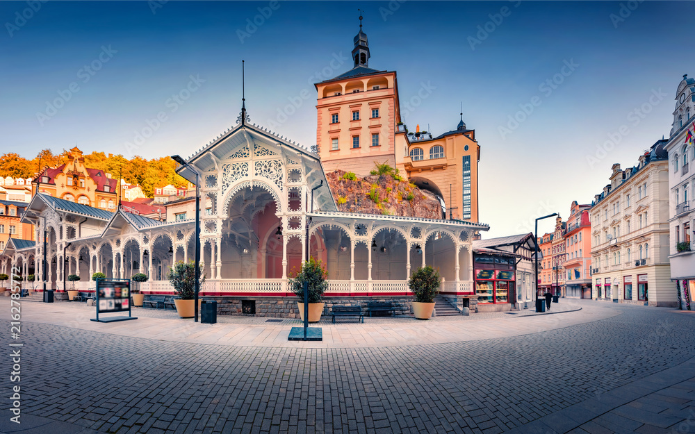 Obraz premium Beautiful morning view of popular tourist attraction - Market Colonnade and Castle Tower on background. Stunning summer cityscape of Karlovy Vary (Carlsbad) town, Czech Republic.