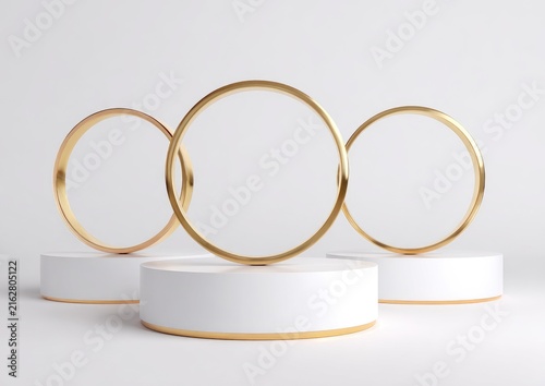 Three gold ring forms stand on white cylindrical platforms against a plain white background, creating an elegant minimalist composition
