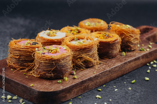 Photography Middle Eastern Kataifi desserts arranged on a wooden board