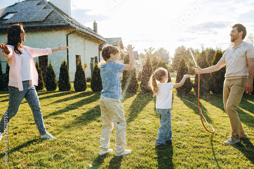 Canvas Print Family playing with water enjoying summer backyard fun