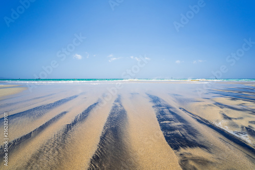Sandy beach with water patterns at Playa de Sotavento de Jandia, Fuerteventura.