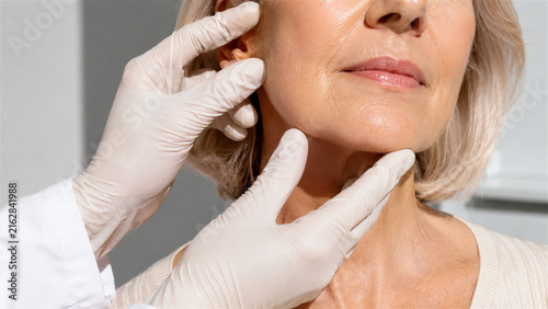 woman receiving facial skin examination by cosmetic professional. Closeup consultation for wrinkle assessment, skincare treatment, antiaging medicine, and aesthetic healthcare
