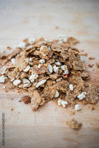 Müsli zum Frühstück– knuspriges Granola mit Nüssen und Kokos auf Holztisch