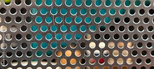 Foto Macro view of a brushed metal sheet with circular perforations arranged in a regular grid
