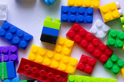 Konstfotografi Colorful plastic building blocks toy pieces scattered on a white background,Top
