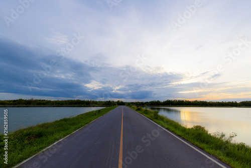 Fotografie Asphalt Road Through Coastal Mangrove Forest at Sunset,An empty, scenic asphalt