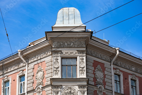 Ornate pink corner building with domed turret and pediment window