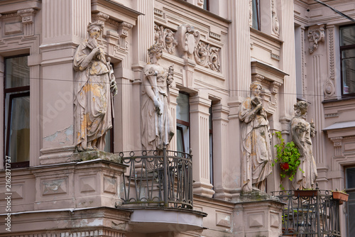 фотографія Weathered caryatid statues on an ornate historic building facade