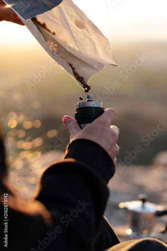 Morning Ritual grinding coffee in nature while camping in the mountains